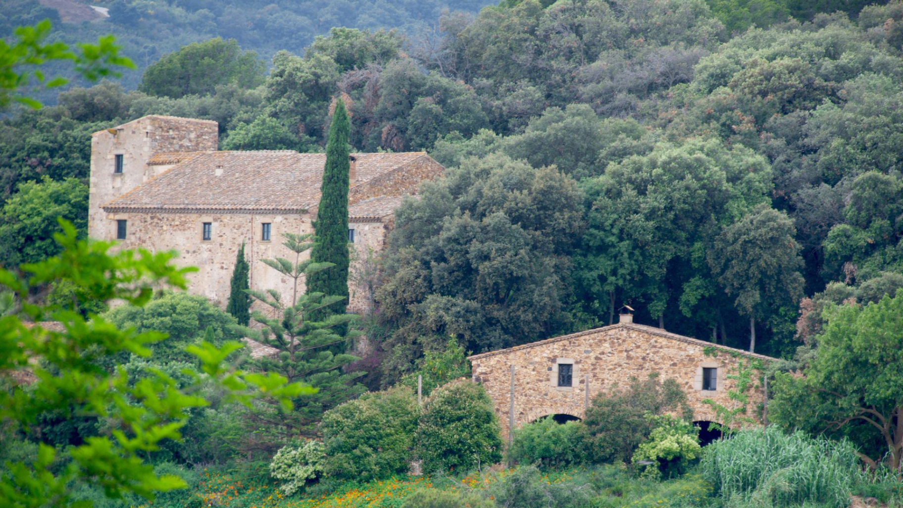 Casa de pedra amb arbres i muntanyes a Catalunya